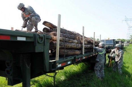 Soldiers from the 1195th Transportation Company, Nebraska Army National Guard, prepare to unload forest timber at Fort Thompson, S.D., as a part the 29th annual Golden Coyote training exercise June 11, 2013. The National Guard Soldiers delivered the timber from the Black Hills National Forest to Crow Creek Sioux Tribe members as a part of the two-week training exercise. (U.S. Army National Guard photo by Maj. Anthony Deiss) 